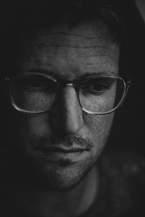 somber man with glasses